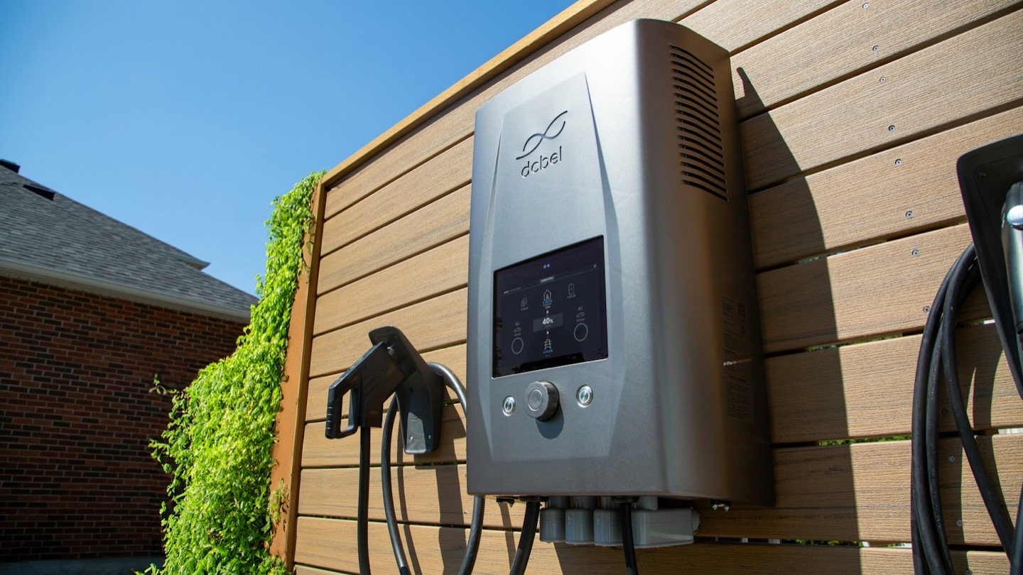 An electric-vehicle charging unit and cable mounted on a wall, ready to charge