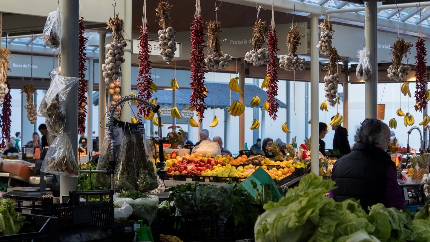 Fresh fruit, vegetables and produce on display at a busy covered market